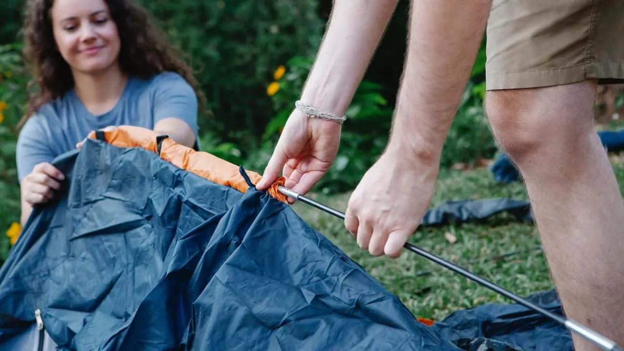 People pitching a wild camping tent