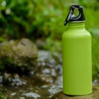 Green Hydro Flask on a stone