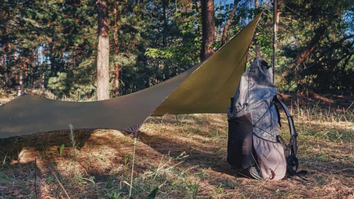 Backpack next to a tarp tent